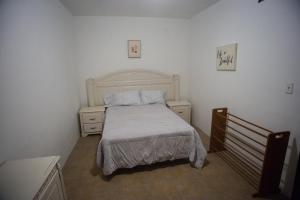 ein kleines Schlafzimmer mit einem Bett und zwei Nachttischen in der Unterkunft Casa Genova, casa amplia y comoda, terraza privada in Ciudad Juárez
