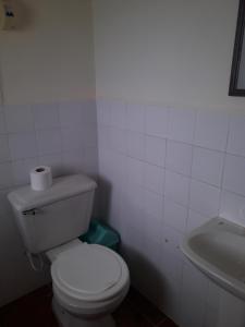 a white bathroom with a toilet and a sink at Inka Wasi in Isla de Sol