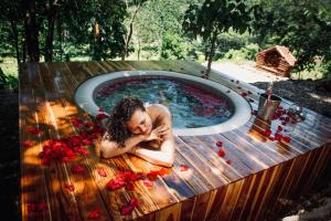 a woman laying in a pool with red roses at Skala Glamping in Pore
