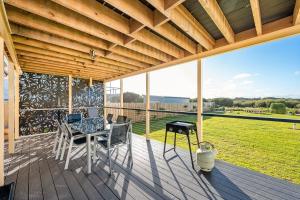 une terrasse en bois avec une table et des chaises. dans l'établissement Sea Breeze 3BR WIFI Family and Pet friendly, à Middleton