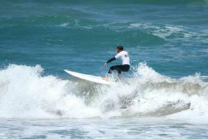 un homme faisant une vague sur une planche de surf dans l'océan dans l'établissement Sea Breeze 3BR WIFI Family and Pet friendly, à Middleton