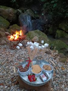 a table with food and a fire in the background at Skala Glamping in Pore