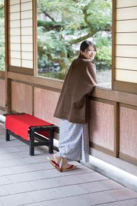 uma mulher está olhando para fora de uma janela em Arima Onsen Gekkoen Yugetsusanso em Kobe