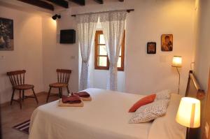 a bedroom with a bed with two chairs and a window at Villa Sa Capsana in Valldemossa