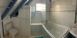 La salle de bains est pourvue de toilettes, d'une baignoire et d'un lavabo. dans l'établissement Paradise chez Nono, à Baie-Mahault