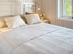 - un lit blanc dans une chambre avec fenêtre dans l'établissement Holiday home OSKARSHAMN IV, à Oskarshamn