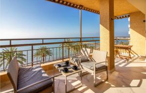 balcón con sillas, mesa y vistas al océano en Awesome Apartment In Santa Pola With Wifi And 4 Bedrooms, en Santa Pola