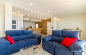 - un salon avec deux canapés bleus et des oreillers rouges dans l'établissement 4 Bedroom Lovely Apartment In Santa Pola, à Santa Pola