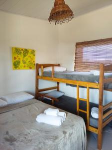 a room with two bunk beds and a chandelier at Pousada dos Cardeais in Barra Grande