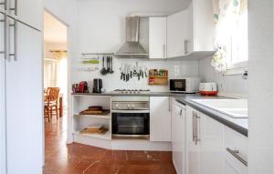 Una cocina con gabinetes blancos y un horno de estufa. en 4 Bedroom Gorgeous Home In Campello, en Carrer del Mar