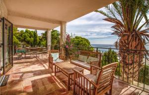 un balcón con sillas, mesas y una palmera en 4 Bedroom Gorgeous Home In Campello, en Carrer del Mar 19 fotos más