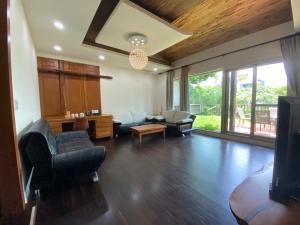 a living room with a couch and chairs and a tv at 五柳園休閒農場-嘉義市民宿001號 in Chiayi City