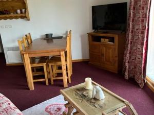 salon ze stołem i telewizorem oraz stołem i krzesłami w obiekcie Superbe 3 Pièces avec Terrasse, Parking Privé et WIFI - 6 Couchages à Orcières - FR-1-262-178 w mieście Orcières
