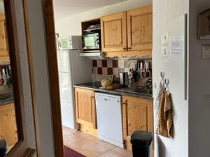 kuchnia z drewnianymi szafkami i białą lodówką w obiekcie Superbe 3 Pièces avec Terrasse, Parking Privé et WIFI - 6 Couchages à Orcières - FR-1-262-178 w mieście Orcières +5 zdjęć