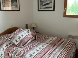 łóżko z paskowym kocem i poduszkami w obiekcie Superbe 3 Pièces avec Terrasse, Parking Privé et WIFI - 6 Couchages à Orcières - FR-1-262-178 w mieście Orcières