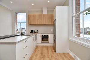 uma cozinha com armários brancos e uma grande janela em Kaiapoi Luxury Accommodation 2 - Bookahome em Kaiapoi
