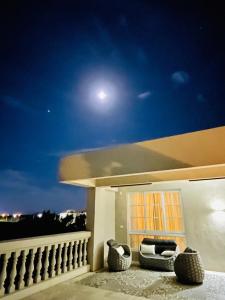 a balcony of a house at night with the moon at #66 Homestay in Magong