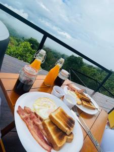 a plate of breakfast food with bacon and eggs on a table at La Paloma Glamping in Palestina