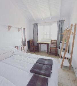1 dormitorio con 1 cama, mesa y sillas en La Puerta Azul en Tandil