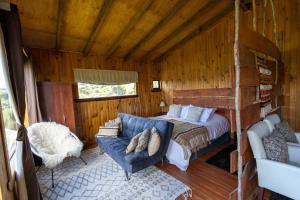 Vertientes De Pumillahue, Chiloe في Pumillahue: غرفة نوم بسرير واريكة في غرفة