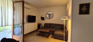 een woonkamer met een bank, een tv en een spiegel bij san felice in Manerba del Garda