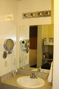a bathroom with a sink and a mirror at Empire Inn & Suites in Red Deer