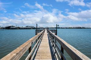 un muelle de madera sobre el agua con una ciudad en el fondo en Sangria Sunset, en Rockport