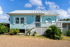 una casa azul con porche y escaleras delante en Sangria Sunset, en Rockport