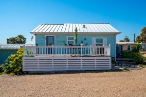 una pequeña casa azul con un porche blanco en Sangria Sunset, en Rockport