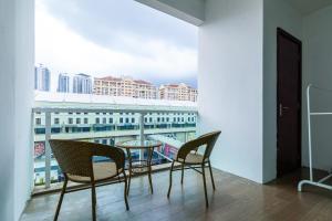 uma varanda com cadeiras, uma mesa e uma vista em Plaza Damas by Plush em Kuala Lumpur
