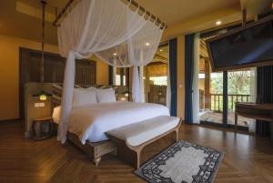 a bedroom with a bed and a flat screen tv at Le Champ Tu Le Resort Hot Spring & Spa in Yen Bai