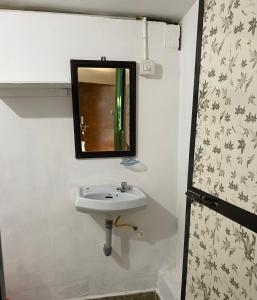 a bathroom with a sink and a mirror at Chill Out Jasmine Restaurant Bar Rooms in Palolem