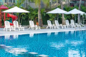 a group of chairs and umbrellas next to a swimming pool at Sunflower International Village in Hai Phong