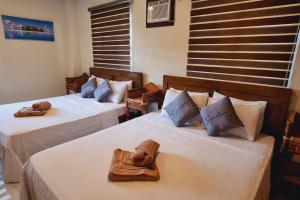 a room with two beds with towels on them at Balay sa bukid (1bedroom) in Boracay