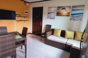 a living room with a couch and chairs and a television at Balay sa bukid (1bedroom) in Boracay
