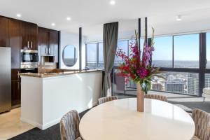 a kitchen with a table and chairs and a large window at Meriton Suites Kent Street, Sydney in Sydney