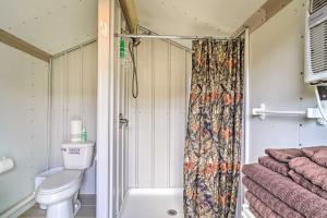 y baño con aseo y cortina de ducha. en Outdoor Retreat Huntsville Cabin with Mtn View, en Huntsville