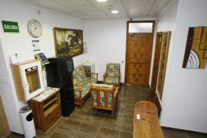 a room with chairs and a clock on the wall at Hostal San Fernando in Alicante