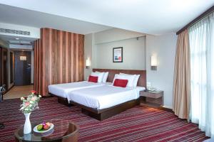 a hotel room with a bed and a table at Ambassador Hotel Bangkok - SHA Extra Plus in Bangkok