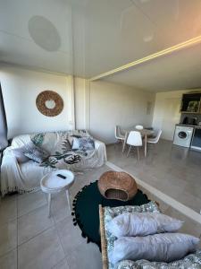un soggiorno con un divano e un tavolo di Le Studio de la Lagune studio cabine proche de la plage a Le Grau-du-Roi