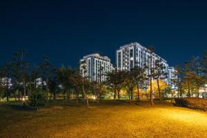 dos altos edificios blancos en un parque por la noche en Chestertons Sokcho, en Sokcho