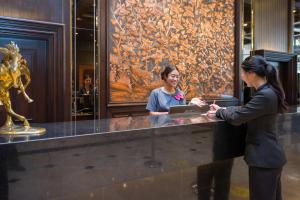 two women standing at a counter in a museum at Ambassador Hotel Bangkok - SHA Extra Plus in Bangkok