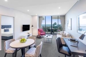 Suite de hotel con sala de estar y dormitorio en Meriton Suites Kent Street, Sydney, en Sídney