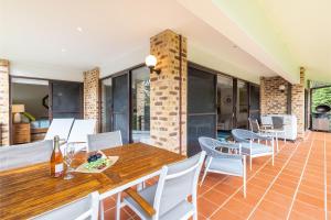 a dining room with a wooden table and chairs at Bay Parklands, 49 2 Gowrie Ave - ducted aircon, Wifi, views, pool, tennis in Nelson Bay