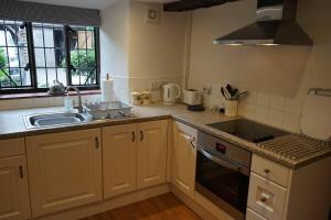 a kitchen with a sink and a stove top oven at Stunning Historic 2-Bed House in Shaftesbury in Shaftesbury
