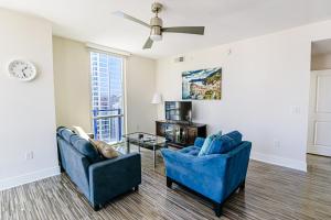 a living room with two blue chairs and a table at Uptown Charlotte 2BR Furnished Apartments apts in Charlotte
