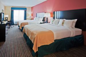 Habitación de hotel con 2 camas y escritorio en Holiday Inn Titusville/Kennedy Space Center, an IHG Hotel en Titusville