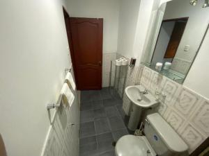 y baño con lavabo, aseo y espejo. en SUITES AMOBLADA, en Guayaquil
