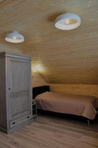 a bedroom with a bed and two lights on the ceiling at Magura little chalet in Măgura