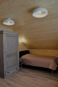 a bedroom with a bed and two lights on the ceiling at Magura little chalet in Măgura